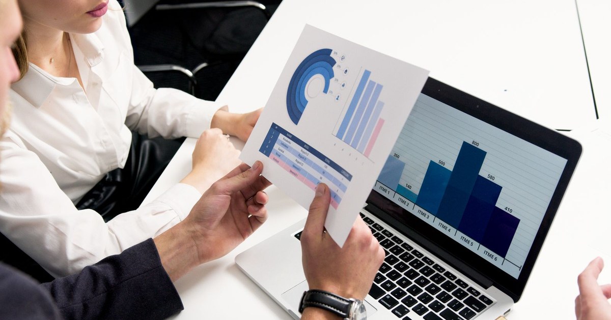 Two finance professionals reviewing transfer pricing analysis and benchmarking reports for an Indian subsidiary