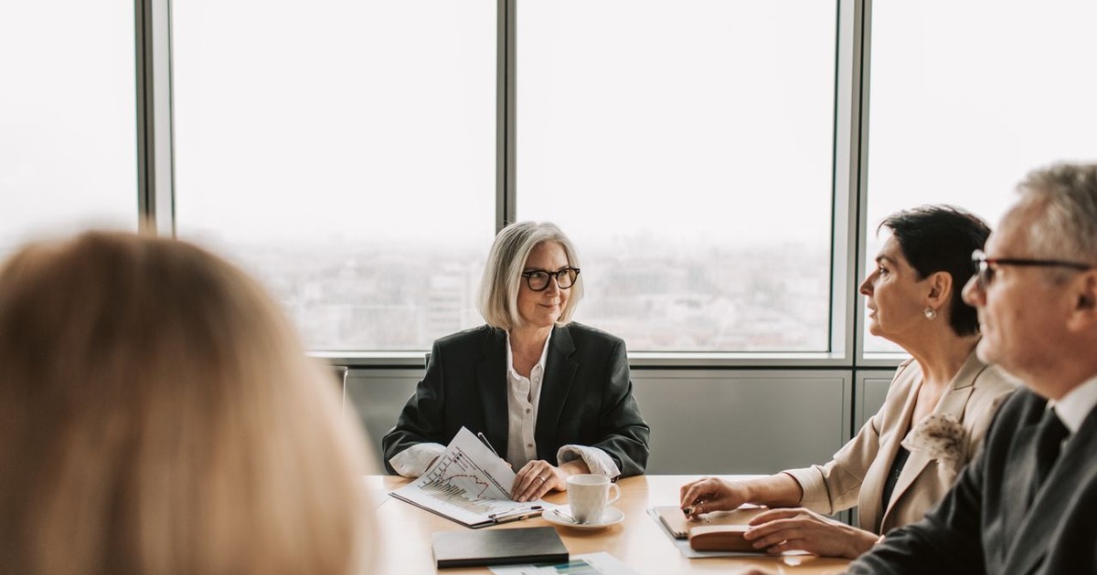 Advisors reviewing figures across a boardroom table while discussing valuation methods